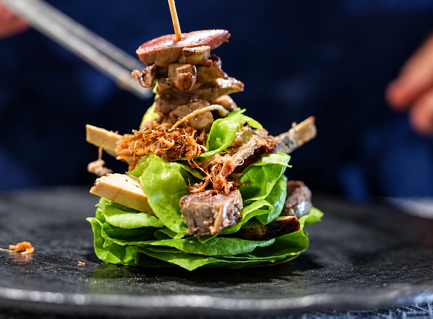 Tour de salade et de viande sur une assiette noire